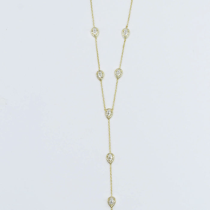 Dainty gold layered necklace, boutique wholesale jewelry, waterproof gold necklace, hypoallergenic and tarnish free statement accessory featuring a gold lariat necklace with clear teardrop pendants