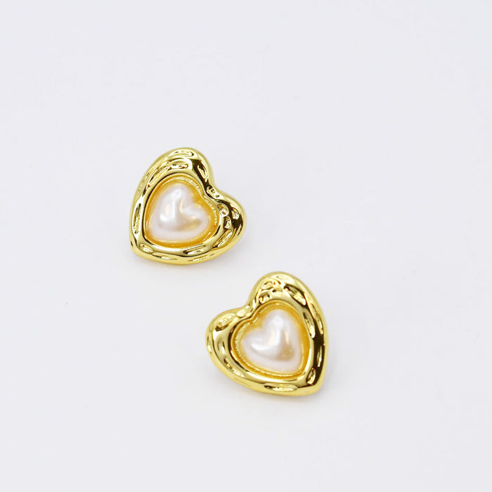 Gold heart stud earrings tarnish-free hypoallergenic waterproof wholesale earrings for boutique, Pearl heart detail, Glossy gold outline, Iridescent pearl center, Sculpted heart design, Shiny gold frame, Soft pearl sheen, Polished metallic finish, Delicate heart shape, Elegant pearl texture, Refined gold contour, Classic heart style