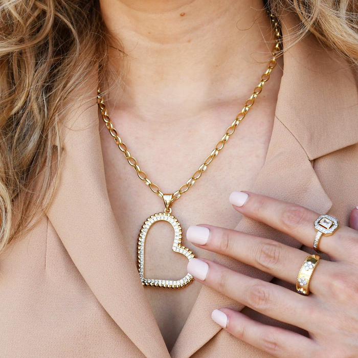 Dainty gold layered necklace, boutique wholesale jewelry, waterproof gold necklace, hypoallergenic and tarnish free statement accessory featuring a gold chain necklace with an open heart pendant adorned with small crystals