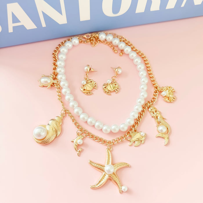 Dainty gold layered necklace set with pearls and sea charms, trendy statement accessory for wholesale jewelry for women’s boutiques, boutique wholesale jewelry, waterproof necklaces that are hypoallergenic and tarnish free